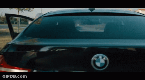 The Back Of A Black Bmw With The Door Open And A Bmw Logo GIF