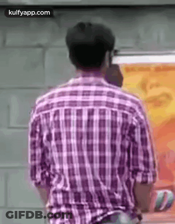 The Back Of A Man In A Plaid Shirt Is Shown . GIF