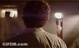 The Back Of A Man 'S Head Is Shown In A Dark Room . GIF