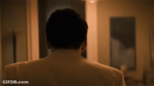 The Back Of A Man 'S Head Is Shown In A Room With A Painting In The Background . GIF