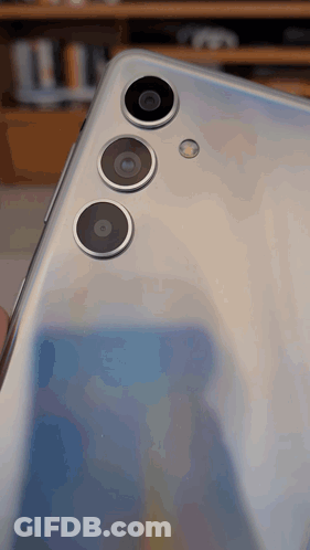 The Back Of A Silver Phone With Three Cameras GIF