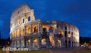 The Colosseum Is Lit Up At Night With A Blue Sky GIF