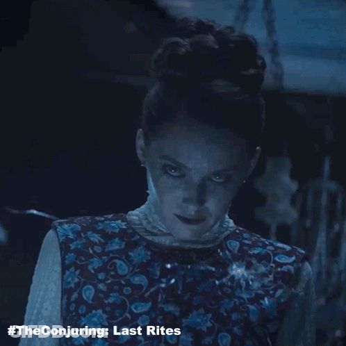 The Conjuring Last Rites Poster With A Woman In A Floral Vest GIF