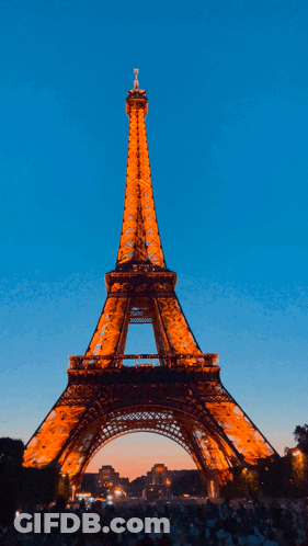 The Eiffel Tower Is Lit Up At Night GIF
