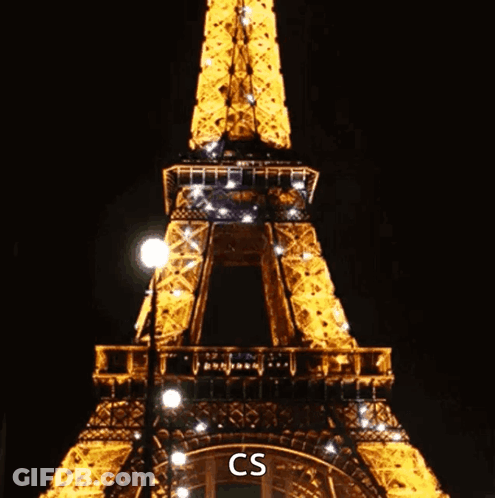 The Eiffel Tower Is Lit Up At Night And Says Cs On The Bottom Right GIF