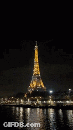 The Eiffel Tower Is Lit Up At Night In Paris , France . GIF