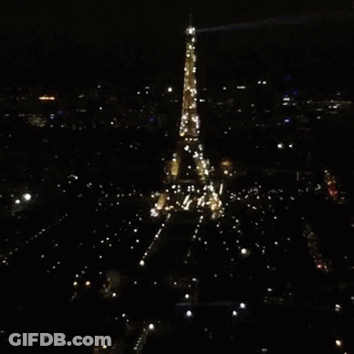 The Eiffel Tower Is Lit Up At Night GIF