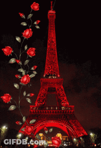 The Eiffel Tower Is Lit Up With Red Lights At Night GIF