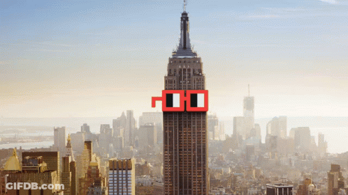 The Empire State Building Is Surrounded By A City Skyline And Has A Pair Of Red Glasses On The Top Of It GIF