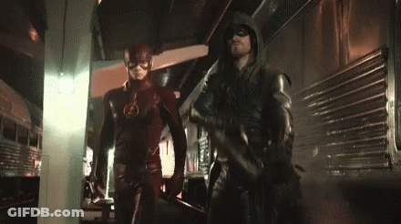 The Flash And Green Arrow Are Standing Next To Each Other In A Dark Room . GIF