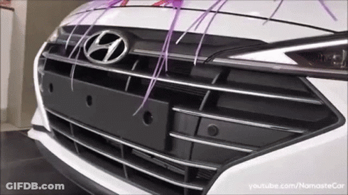 The Front Of A White Hyundai Car With Purple Ribbons GIF