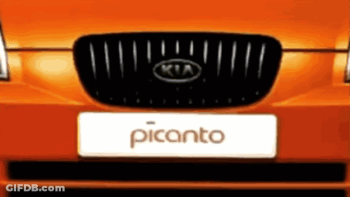 The Front Of An Orange Kia Picanto With A Black Grill GIF