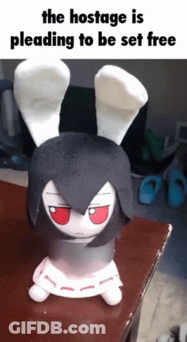 The Hostage Is Pleading To Be Set Free With A Stuffed Bunny On A Table GIF