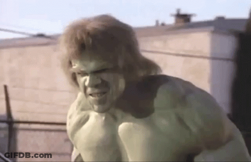 The Hulk Is Standing In Front Of A Building With A Serious Look On His Face . GIF