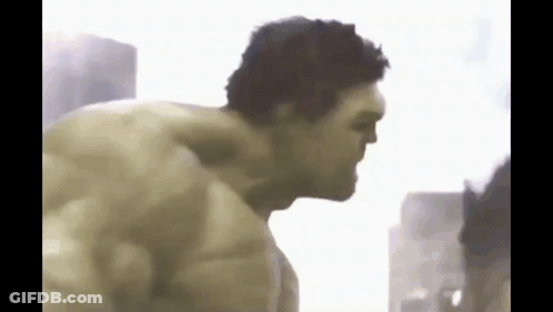 The Hulk Is Without A Shirt And Is Standing In Front Of A Building . GIF