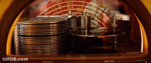 The Inside Of A Jukebox With A Stack Of Records On The Bottom Shelf GIF