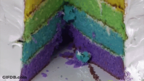 The Inside Of A Rainbow Cake With A Slice Taken Out Of It GIF