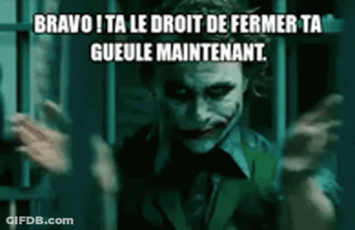 The Joker From The Movie The Dark Knight Is Standing In Front Of A Prison Cell With His Hands Outstretched . GIF