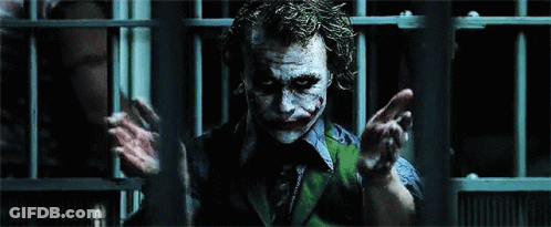 The Joker Is Behind Bars In A Dark Room GIF