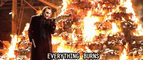 The Joker Is Standing In Front Of A Pile Of Burning Barrels With The Words Everything Burns Below Him GIF