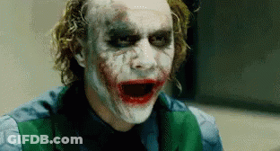 The Joker Is Wearing A Green Vest And Making A Funny Face . GIF