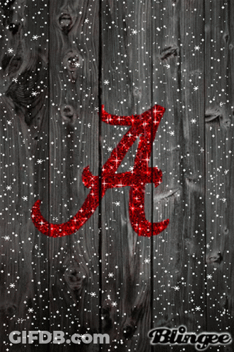 The Letter A Is Written In Red Glitter On A Wooden Surface GIF