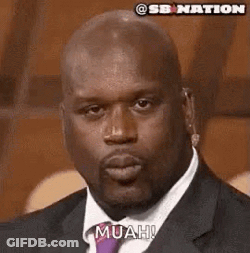 The Man Is Wearing A Suit And Tie And Blowing A Kiss . GIF