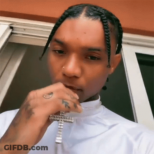 The Man Is Wearing A White Shirt And A Cross Necklace . GIF