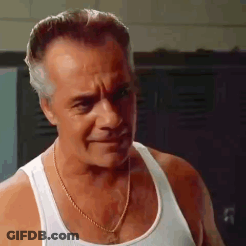 The Man Is Wearing A White Tank Top And A Gold Chain Around His Neck . GIF