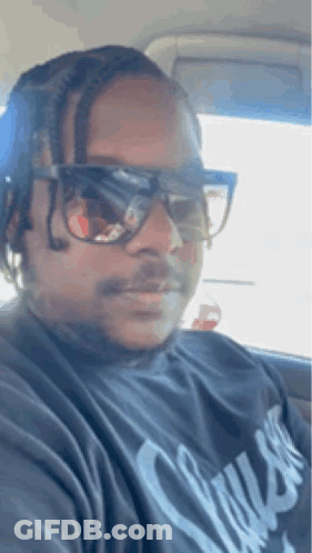 The Man Is Wearing Sunglasses And A Black Shirt . GIF