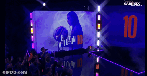 The Number 10 Is Projected On A Wall Behind A Crowd Of People GIF