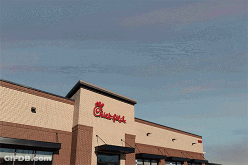 The Outside Of A Chick-Fil-A Restaurant With A Blue Sky Behind It GIF