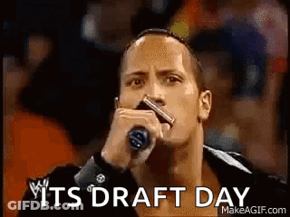 The Rock Is Holding A Microphone In Front Of A Crowd And Says `` It 'S Draft Day '' . GIF