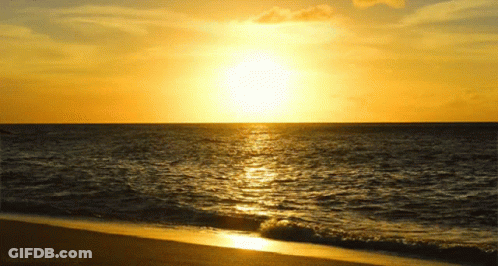 The Sun Is Setting Over A Body Of Water And A Beach Is Visible GIF