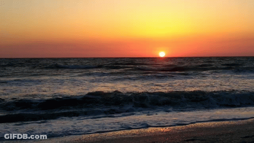 The Sun Is Setting Over The Ocean And The Waves Are Breaking On The Beach GIF