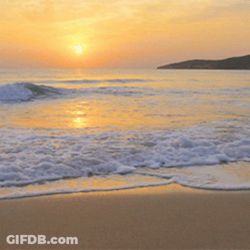The Sun Is Setting Over The Ocean And The Waves Are Coming In GIF