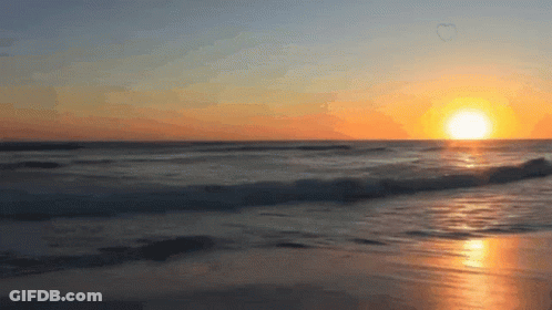 The Sun Is Setting Over The Ocean With A Heart Shaped Bubble In The Sky GIF