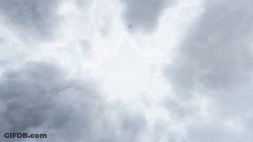 The Sun Is Shining Through The Clouds In A Cloudy Sky . GIF