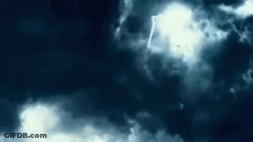The Sun Is Shining Through The Clouds In A Dark Sky . GIF