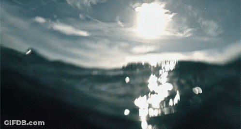 Sun Shining Through Clouds Over Ocean GIF