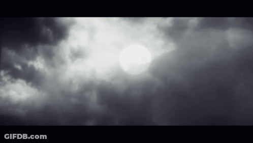 The Sun Is Shining Through The Clouds In The Sky In A Black And White Photo . GIF