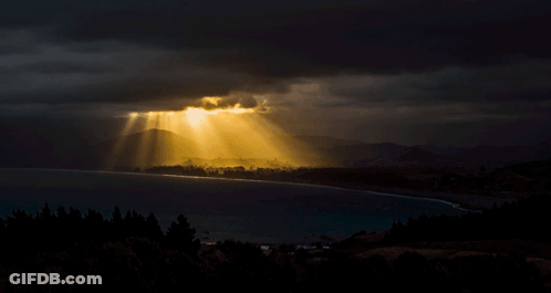 The Sun Is Shining Through The Clouds Over A Lake GIF