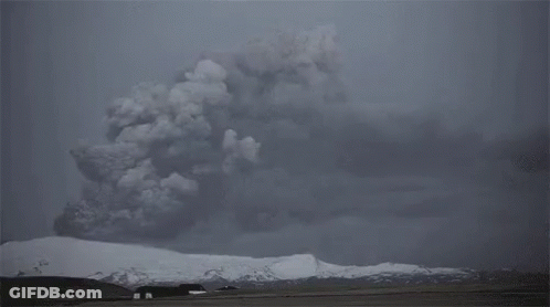 The Sun Is Shining Through The Clouds Over A Snow Covered Mountain . GIF
