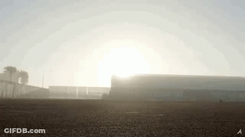 The Sun Is Shining Through The Fog Over A Stadium . GIF