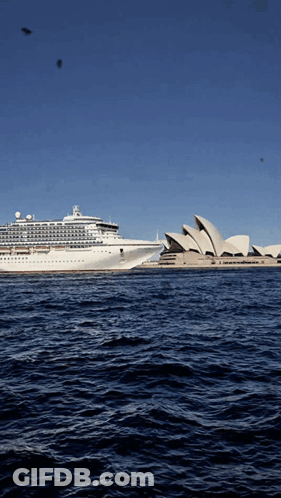 The Sydney Opera House Is Visible In The Distance With A Cruise Ship In The Foreground GIF