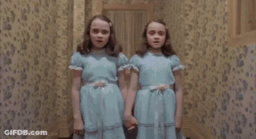 The Twins Are Holding Hands In A Hallway In The Shining Movie . GIF