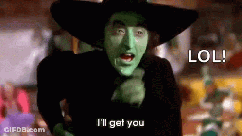 The Wicked Witch From The Wizard Of Oz Is Wearing A Black Hat And Green Paint On Her Face . GIF
