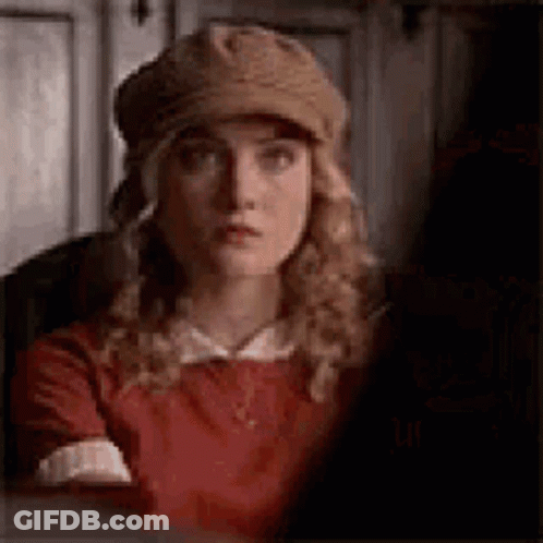 The Woman Is Wearing A Hat And A Red Dress . GIF