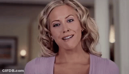 The Woman Is Wearing A Purple Sweater And Smiling . GIF
