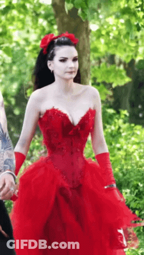 The Woman Is Wearing A Red Dress And Red Gloves . GIF